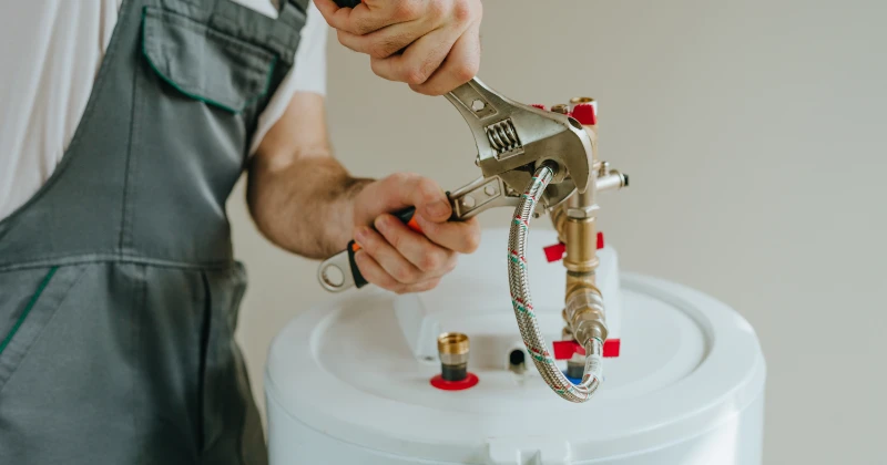 Plombier installant ou réparant un chauffe-eau à Hochelaga-Maisonneuve, Montréal.