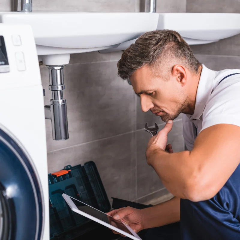 Plombier raccordant un lave-vaisselle dans une résidence à Hochelaga-Maisonneuve, Montréal.